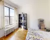 Bedroom featuring radiator, baseboards, and wood finished floors