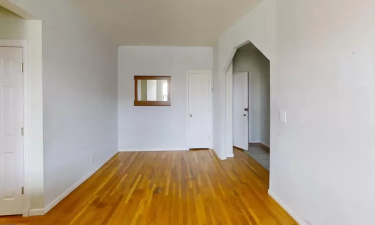 Empty room featuring baseboards and light wood-type flooring