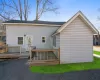 Back of house featuring a deck and a shingled roof