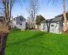 View of yard with an outdoor structure, a storage unit, and fence